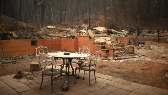 A table and chairs sit in front of a destroyed home in Greenville, California, on Thursday, August 12.