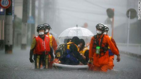 Firefighters rescue stranded residents on a boat in Kurume, Fukuoka, Japan, on August 14.