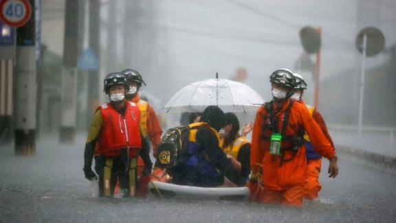 Feuerwehrleute retten am 14. August gestrandete Bewohner auf einem Boot in Kurumi, Fukuoka, Japan.