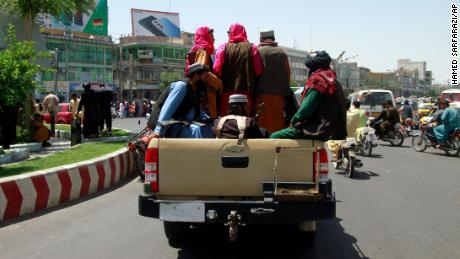 Taliban fighters sit on the back of a vehicle in the city of Herat, west of Kabul on Saturday. 