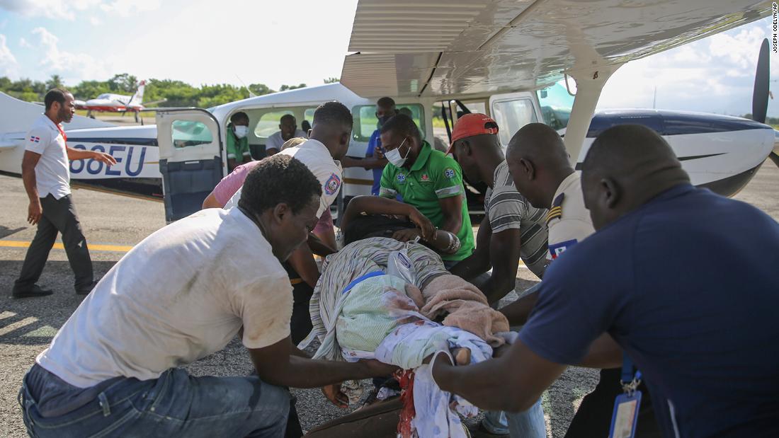 An injured woman is transferred to a plane to be flown to Port-au-Prince, Haiti, on August 14. 