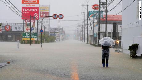 A man walks on a road flooded by heavy rain in southwestern Japan&#39;s Saga Prefecture on Saturday.
