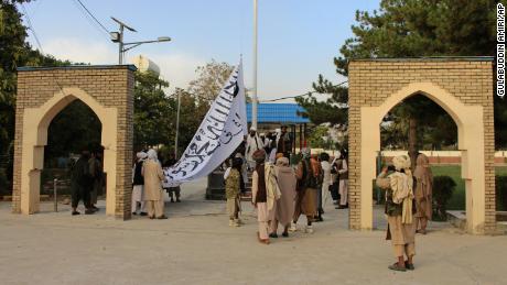 Taliban fighters raise their flag at the provincial governor&#39;s house in Ghazni, southeastern Afghanistan, on August 15, 2021. 