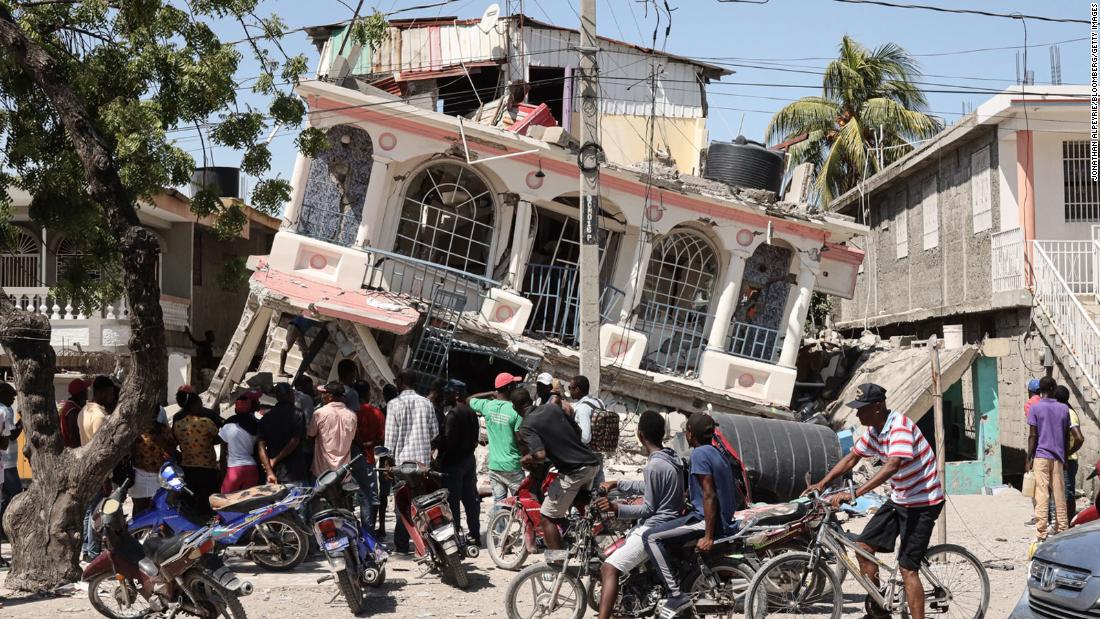 Residents of Les Cayes, Haiti, survey a damaged structure on Sunday, August 15, a day after a 7.2 magnitude earthquake struck the country.