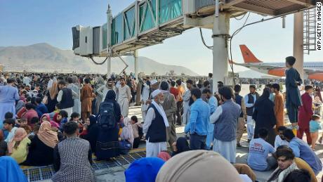 Afghans crowd the tarmac of Kabul&#39;s international airport on Monday.