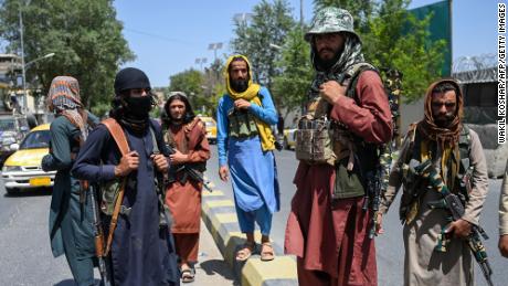 Taliban fighters stand guard along a street near Zanbaq Square in Kabul.