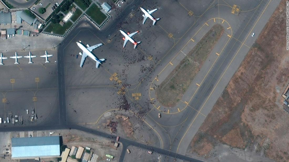 This satellite photo shows swarms of people on the tarmac at Kabul's international airport on August 16.