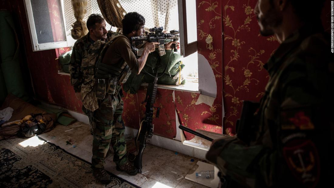 Afghan commandos look out from a window at a home in Kunduz on July 6. The Taliban were moving rapidly to take over districts in northern Afghanistan.