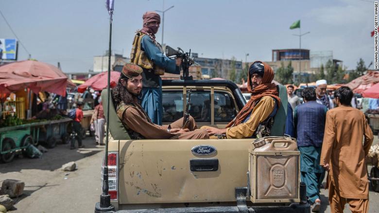 Taliban fighters on a pick-up truck move around a market in Kabul on Tuesday.