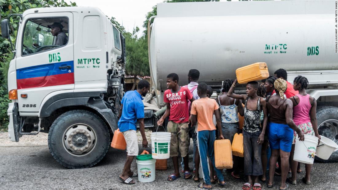 People wait to collect water in Camp-Perrin, Haiti, on August 16.