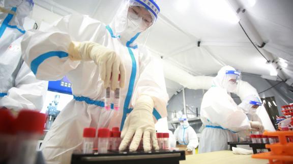 Gli operatori sanitari testano campioni di residenti locali per Covid-19 in un laboratorio di test mobile a Yangzhou, in Cina, il 17 agosto.