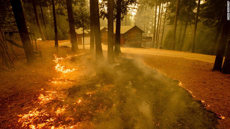 Flames from the Caldor Fire scorch the ground near a home in Grizzly Flats, California, on Wednesday, August 18. 