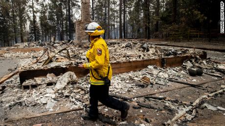 Cal Fire Division Chief Carmel Barnhart inspects a property after the Caldor Fire burned through Grizzly Flats, California. 