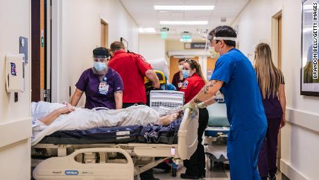 Las enfermeras de la sala de emergencias y los técnicos de emergencias médicas atienden a los pacientes en los pasillos del Houston Methodist Hospital The Woodlands el 18 de agosto de 2021 en Houston, Texas.  En todo Houston, los hospitales han tenido que tratar a cientos de pacientes en pasillos y pasillos ya que sus salas de emergencia están abarrotadas debido al fuerte aumento de casos de variantes delta.