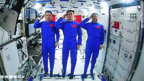 Chińscy astronauci z lewej strony Tang Hongbo, Ni Haisheng i Liu Beoming salutują z pokładu głównego modułu Chińskiej Stacji Kosmicznej 23 czerwca.