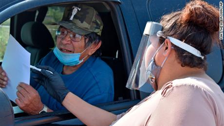 Selena Rides Horse, right, speaks with Gerald Pease at a drive-thru event in Lodge Grass, Montana, last year in effort to urge Crow Indian Tribe members to participate in the 2020 census.