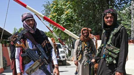 Taliban fighters stand guard along a roadside near the Zanbaq Square in Kabul on August 16, 2021.