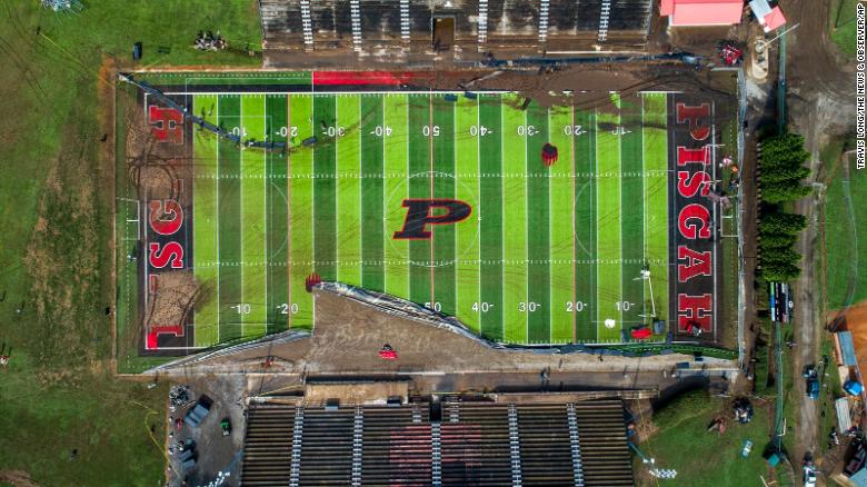 Volunteers on Thursday clear debris and try to salvage athletic equipment at the football field shared by Pisgah High School and Canton Middle School.