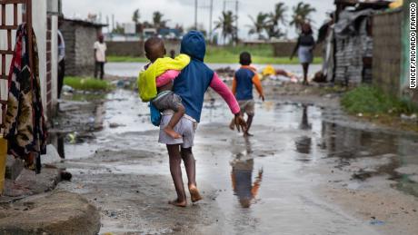 A child walks near rising waters in the Praia Nova neighborhood in Beira, Mozambique, a country where children are at &#39;extremely high risk&#39; from the impact of the climate crisis. 