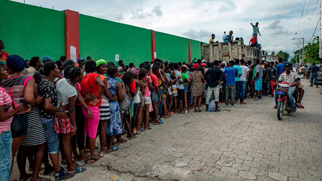 People wait in line for food to be distributed in Les Cayes, Haiti, on Thursday, August 19.