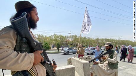 Taliban fighters stand guard at an entrance gate outside the Interior Ministry in Kabul on August 17, 2021. 