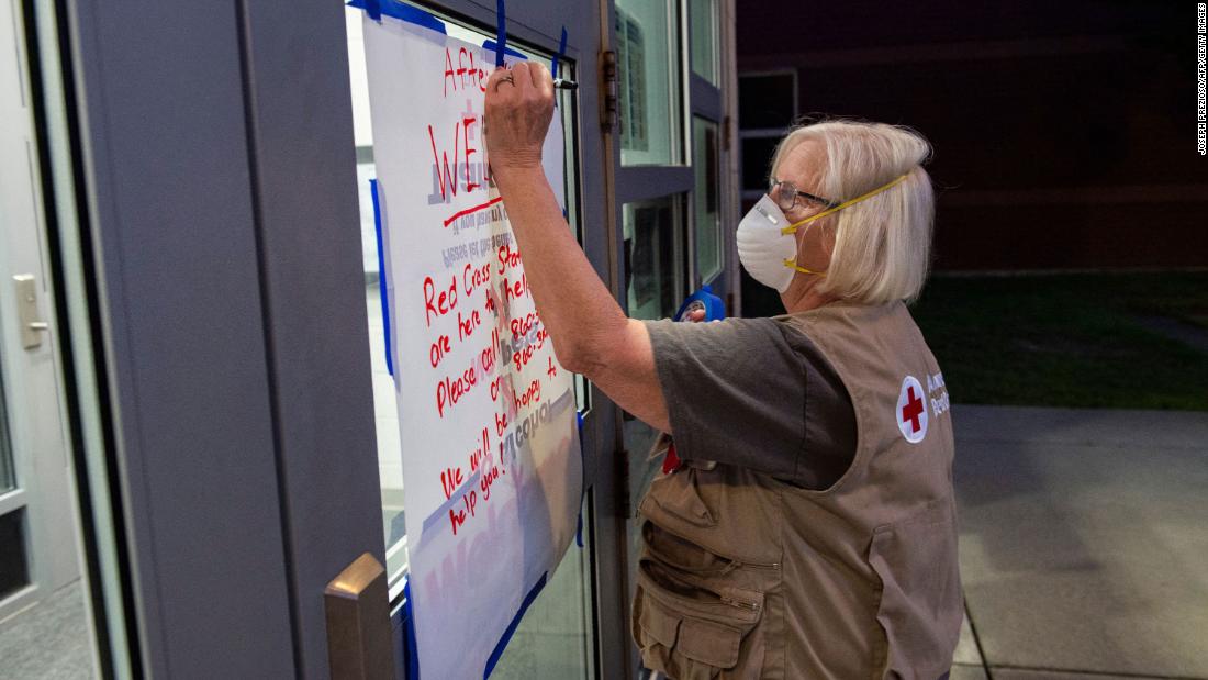 American Red Cross nurse Donna Hathaway works on a welcome poster on the door of the hurricane shelter at East Lyme Middle School in New London, Connecticut, on August 21.