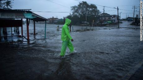 A man walks in a flooded street due to heavy rains caused by Hurricane Grace in Tecolutla, Veracruz, Mexico.