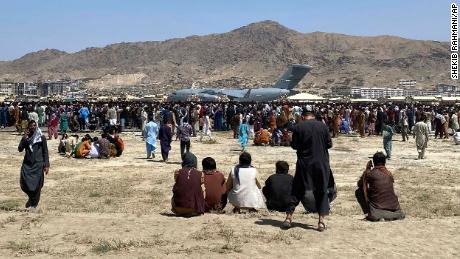 Hundreds of people gather near a US Air Force C-17 transport plane along the perimeter of Kabul International Airport in Afghanistan on August 16.  