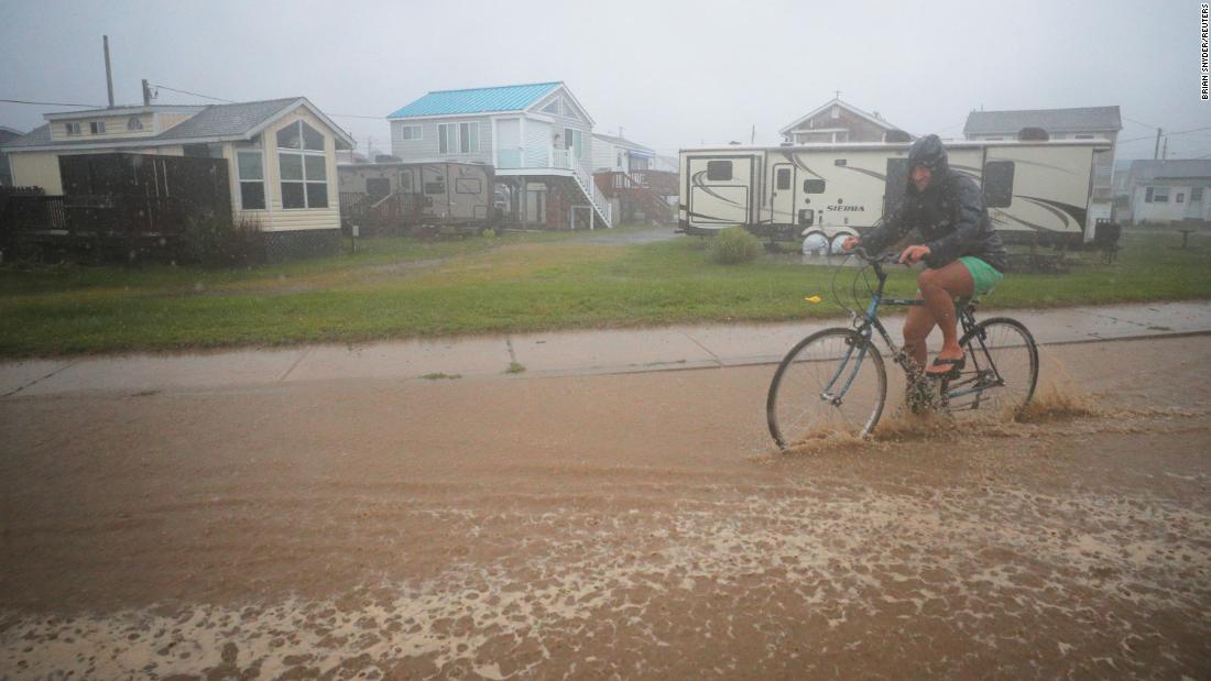 A bicyclist rides through a flooded street as Tropical Storm Henri approaches South Kingstown, Rhode Island, on August 22.