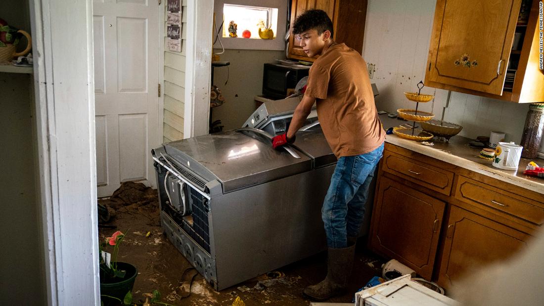 Kalyn Clayton, 16, surveys the damaged kitchen of a home while volunteering with his church youth group in Waverly, Tennessee, on Sunday. 