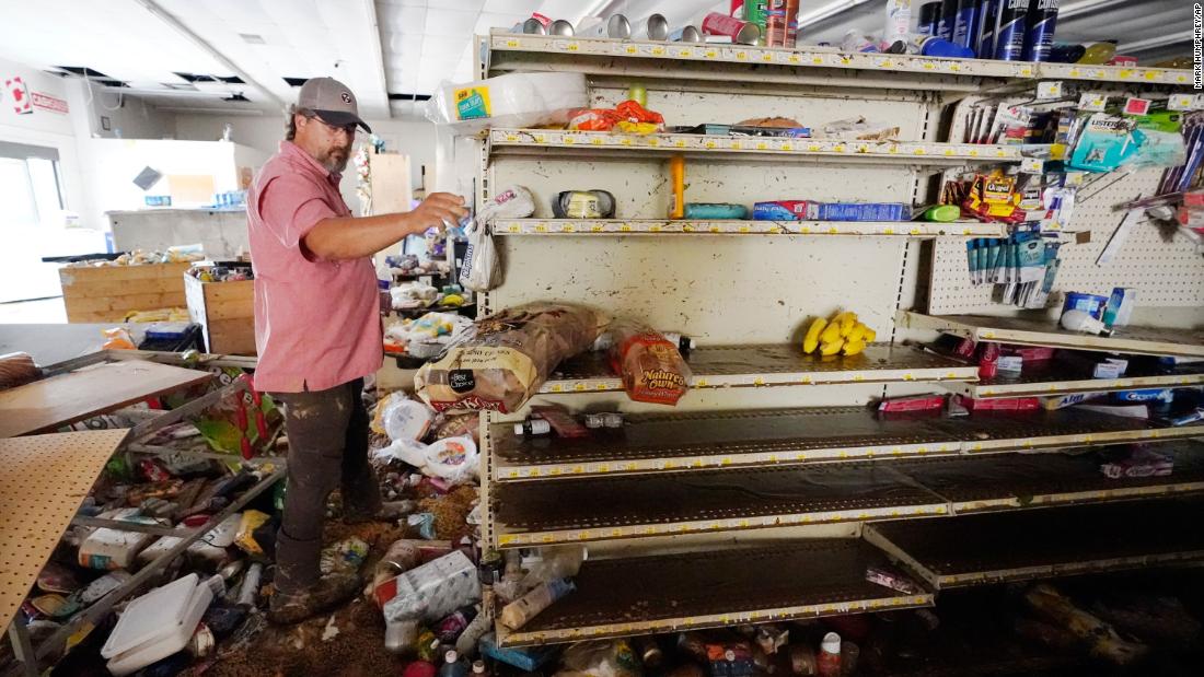 John Curtis, co-owner of the Waverly Cash Saver grocery store, walks through his damaged store.