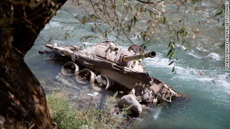 A destroyed Soviet-era tank lies in the Panjshir River in 2016 in Bazarak, Afghanistan. 