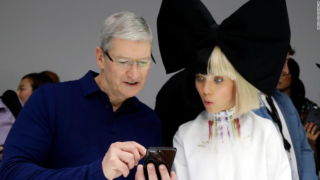 Cook shows an iPhone 7 to performer Maddie Ziegler during an event to announce new products in San Francisco on September 7, 2016.