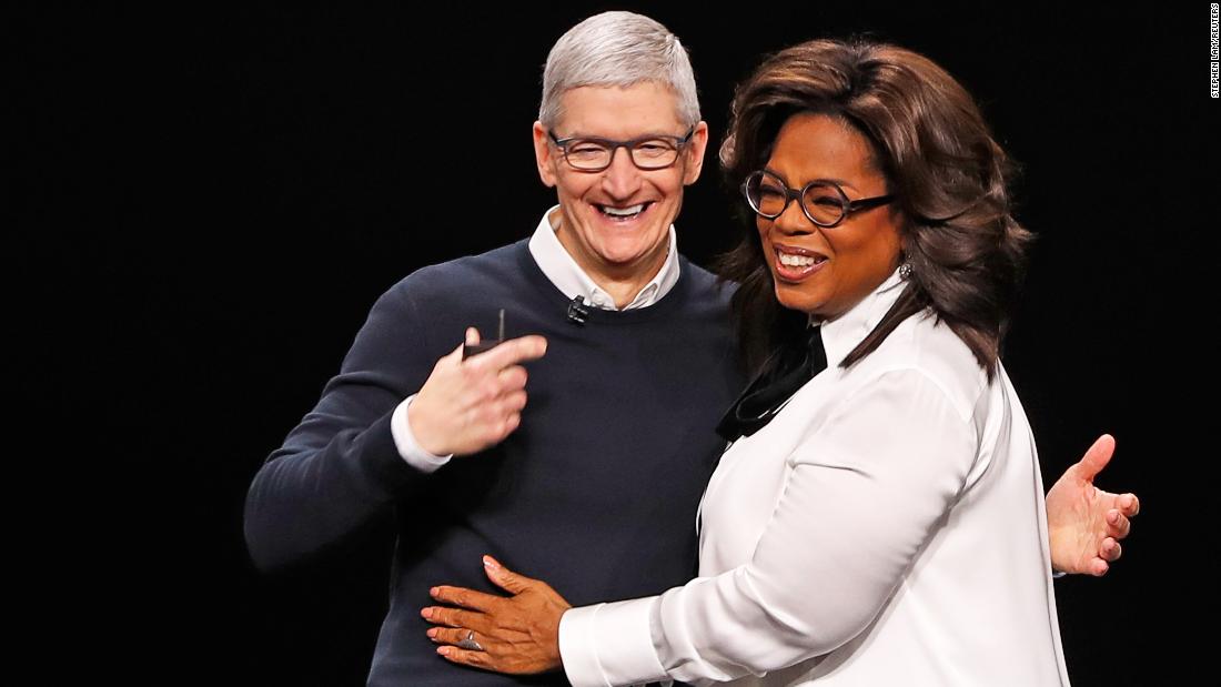 Cook and Oprah Winfrey hug during an Apple special event at the Steve Jobs Theater in Cupertino on March 25, 2019.