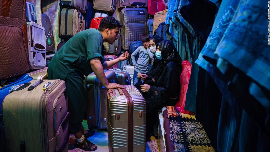 Amir Saib Zada negotiates with customers at his shop that sells luggage and burqas in Kabul&#39;s Lycee Maryam Bazaar on August 22.