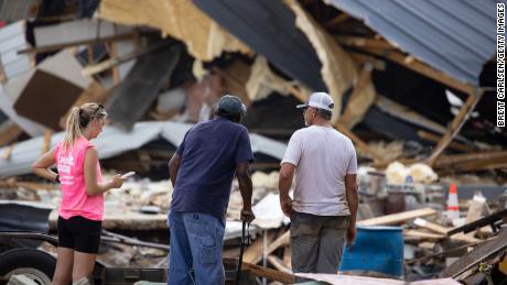 People are looking at cleanup efforts Monday after buildings were destroyed by flooding in Waverly, Tennessee. 