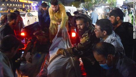 Volunteers and medical staff unload bodies from a pickup truck outside a hospital after the explosion outside the airport in Kabul on August 26.