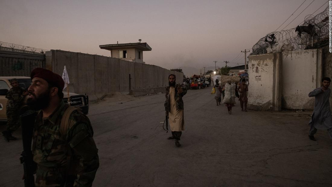 Taliban members guard a road near the airport after the bombing on Thursday.