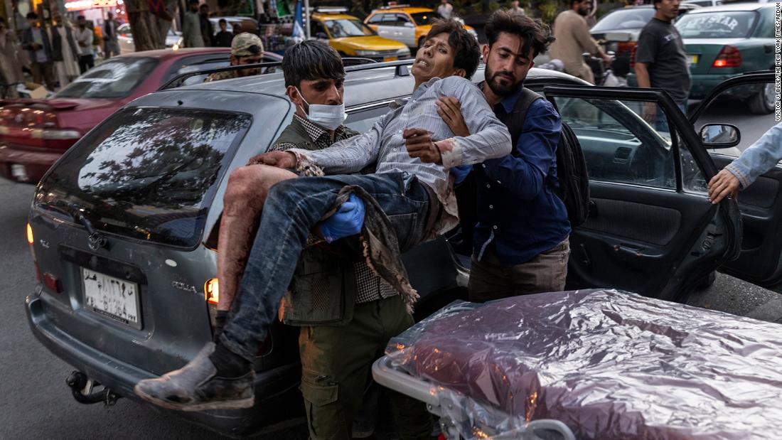 A person injured in a bomb blast is carried outside a Kabul hospital on Thursday.