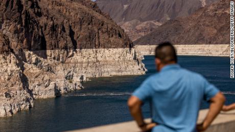 A visitor at the Hoover Dam Lookout observation deck above the Colorado River during low water levels in Arizona, Nevada, U.S., on Thursday, Aug. 19, 2021. 