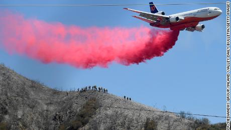 A DC-10 tanker makes a fire retardant drop as hand crews watch from below near Lytle Creek on Thursday, Aug. 26, 2021 as efforts continue to stop the South Fire. 