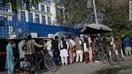 Des Afghans font la queue pour retirer de l'argent à un guichet automatique à Kaboul le 21 août.