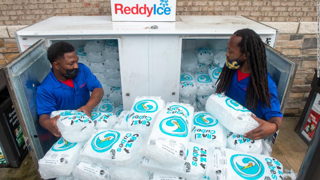Workers stack bags of ice into a gas station freezer in Jefferson, Louisiana, on August 27.