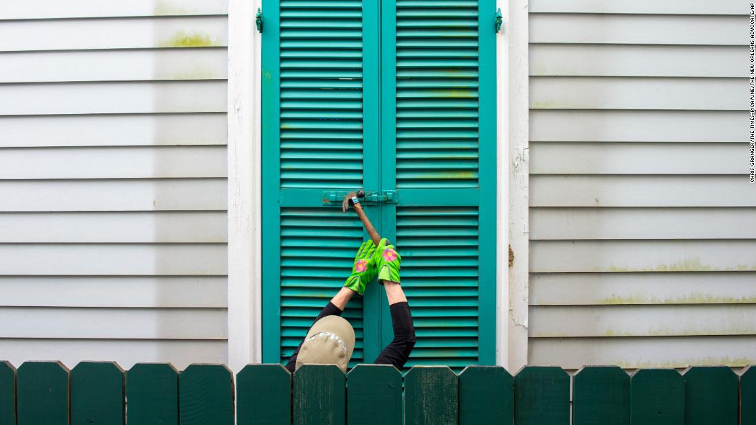 A resident hammers the shutters of a 100-year-old house in New Orleans on August 27.