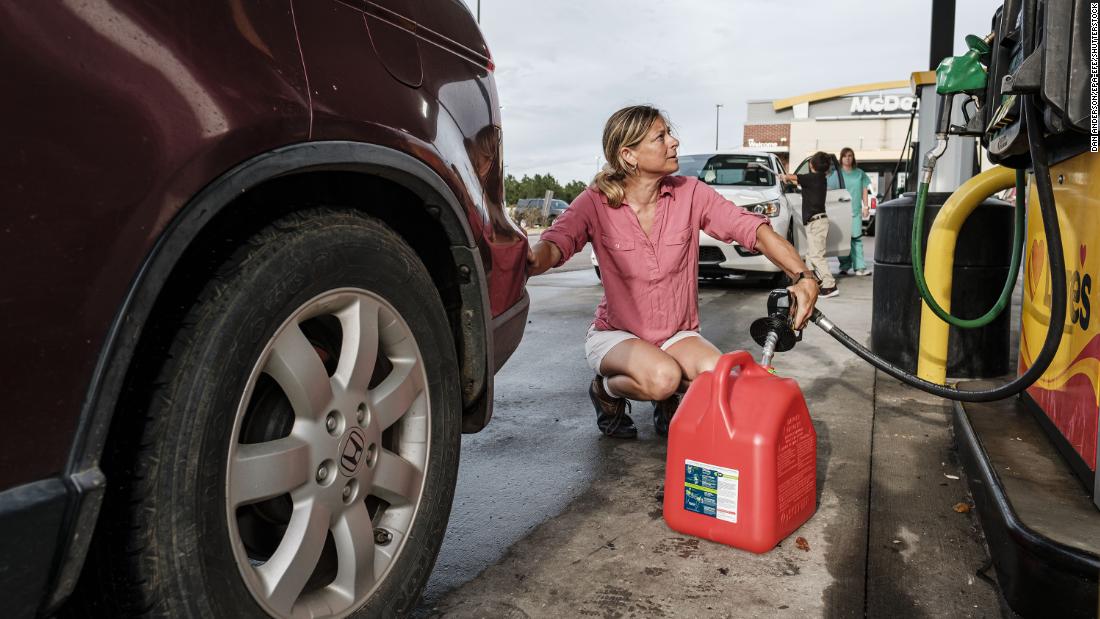 Jennifer Tate fuels up a gas can August 27 in Pass Christian, Mississippi.