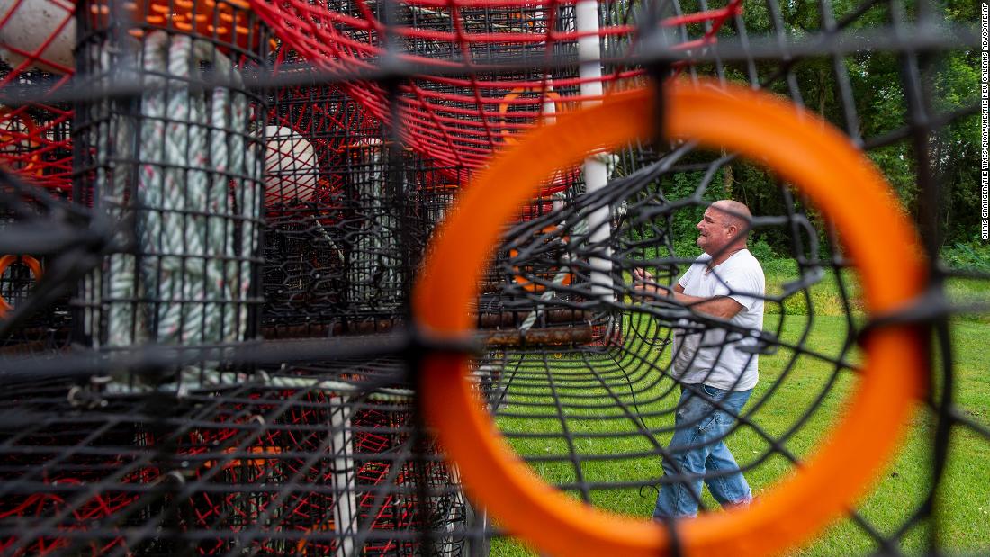 John Guenther unloads about 400 crab traps that he had to pull out of the water and move via flatbed trailer to dry near his home in the eastern St. Bernard Parish on Friday, August 27.