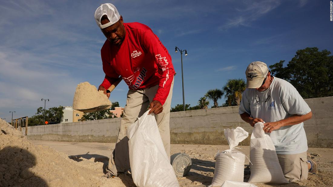 Gregory Moore, left, helps fill sand bags as residents in Gulfport, Mississippi, prepare for the storm on Saturday.
