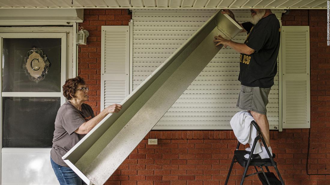 Clare and Joe Cermak work on putting storm shutters up on their home in Louisiana&#39;s St. Charles Parish on August 28.