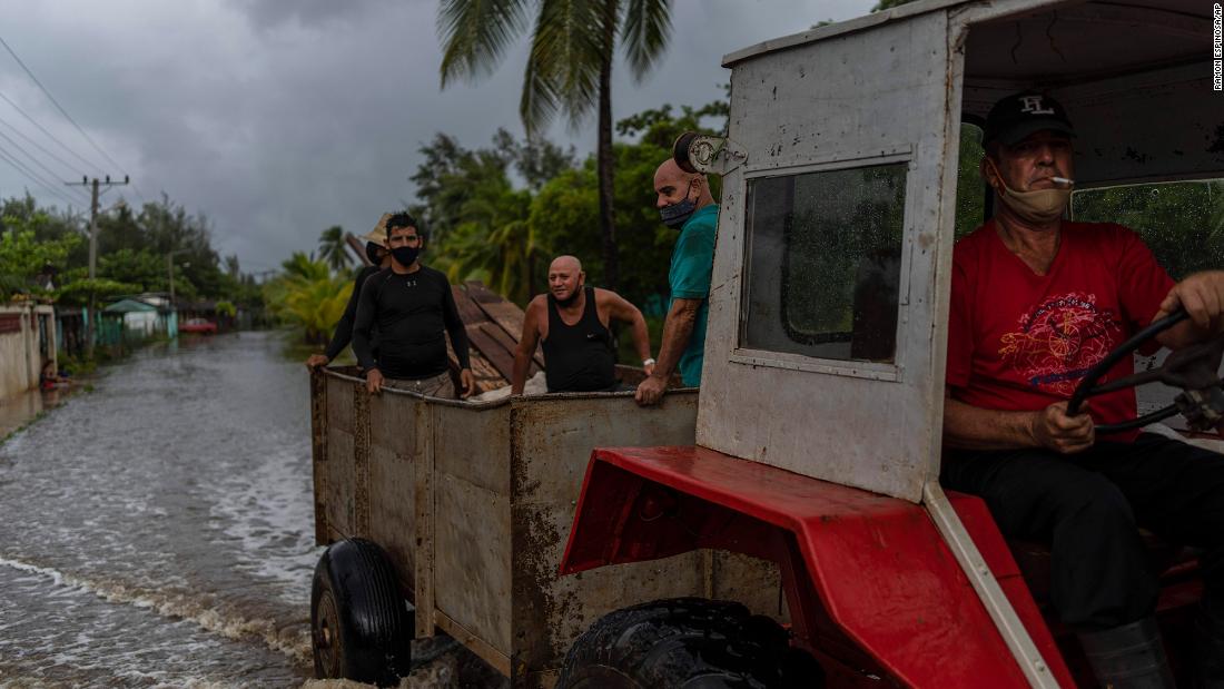 A man drives a tractor through a flooded street Saturday in Guanimar, Cuba. Before entering the Gulf, Ida made landfall twice over Cuba as a Category 1 hurricane.