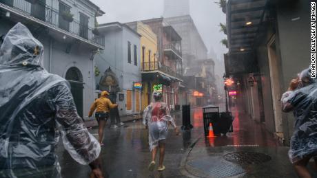 A group of people walk through the French District during Hurricane Ida on August 29, 2021 in New Orleans, Louisiana.